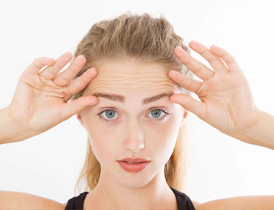 Picture of a female model lifting her brows with her hands