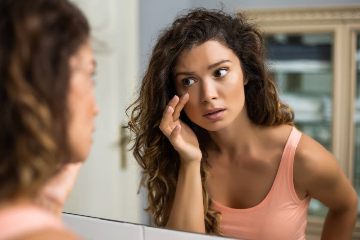 Woman looking at under eye bags.